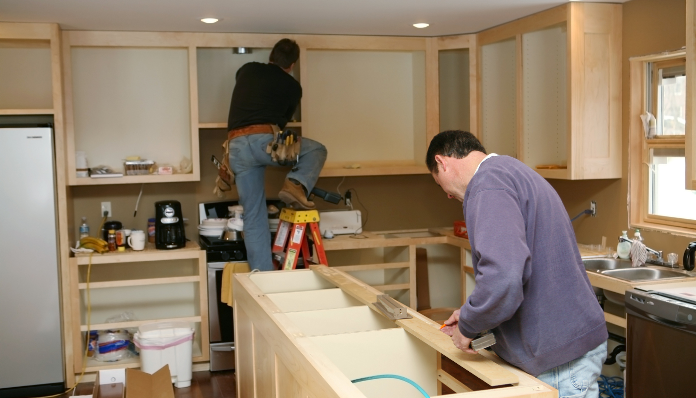 A man working on cabinets in a kitchen