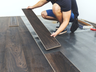 A man is working on a wooden floor