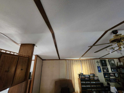 A room with a ceiling fan and a chair