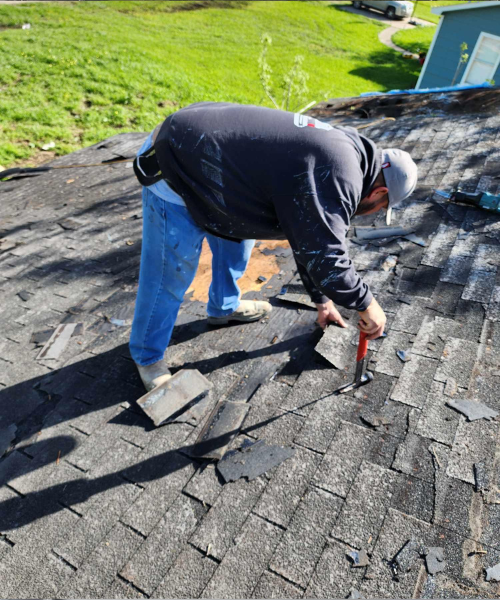 A man working on a roof with a hammer