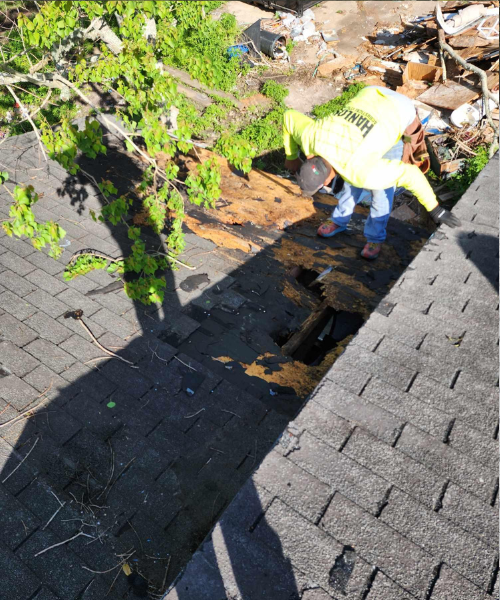 A person with a yellow umbrella is standing on a roof