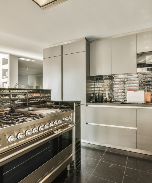 A kitchen with a stove, oven, cabinets and a counter