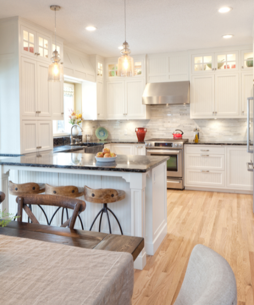 A kitchen with white cabinets and a center island