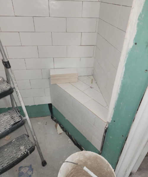 A white toilet sitting next to a step ladder