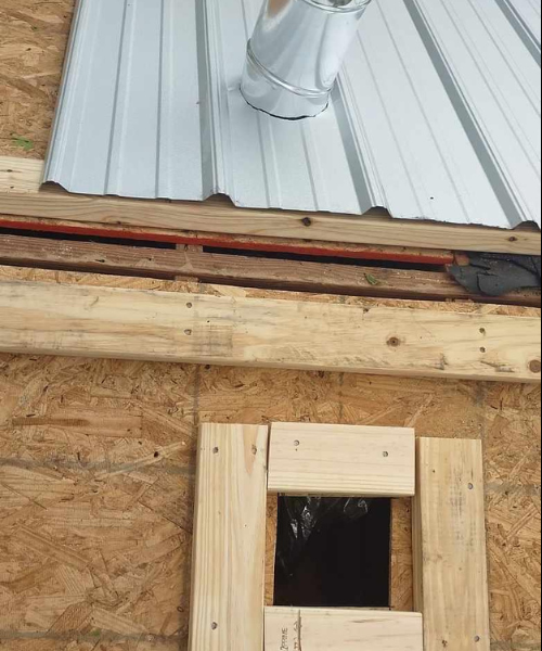 A metal roof with a window in the middle of it